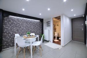 a dining room with a white table and white chairs at loft apartment in Athens +6 photos