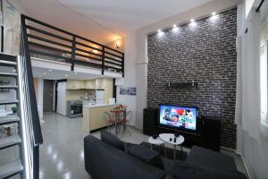 a living room with a couch and a brick wall at loft apartment in Athens
