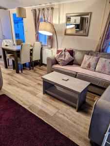 a living room with a couch and a table at Jenny and Jamie's holiday home on the edge in Morecambe