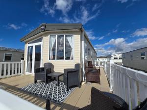 a tiny house on a deck with chairs at Jenny and Jamie's holiday home on the edge in Morecambe