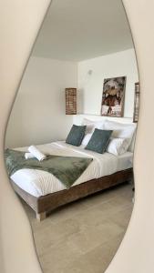 a bedroom with a large bed with a mirror at Suite Balnéo Canet in Canet-en-Roussillon