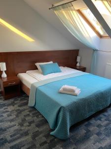 a bedroom with a bed with a blue blanket at Hotel Restauracja Cztery Pory Roku in Orneta
