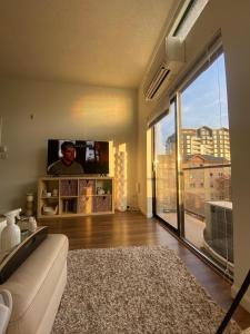 a living room with a couch and a large window at Laid Back In Langford in Langford