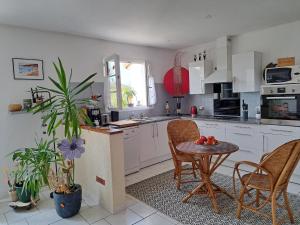 una cucina con tavolo e due sedie e un tavolo con frutta di Chambre au coeur de la Sologne a Romorantin