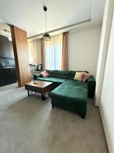a living room with a green couch and a table at Duspara lux apartment Jahorina in Jahorina