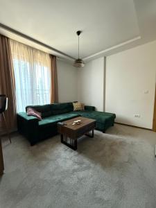 a living room with a green couch and a coffee table at Duspara lux apartment Jahorina in Jahorina