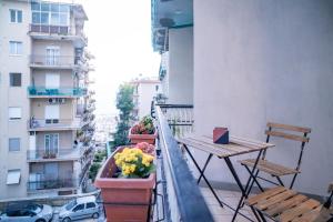 een balkon met 2 stoelen en een tafel en bloemen bij LemonHouse in Napels