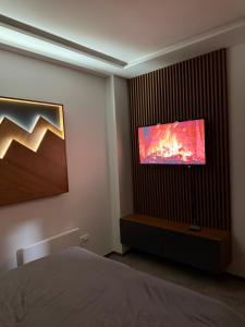 a bedroom with a bed and a flat screen tv at Duspara lux apartment Jahorina in Jahorina