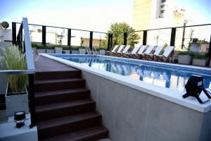 a swimming pool with chairs and a stairway leading to a swimming pool at Semipiso Las Lomitas in Lomas de Zamora