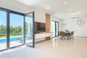 a dining room with a television and a table with chairs at Villa Vivre in Ližnjan