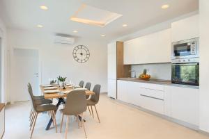 a kitchen and dining room with a table and chairs at Villa Vivre in Ližnjan