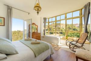 a bedroom with a bed and a large window at Villa con piscina y vista al mar in Moya +72 photos
