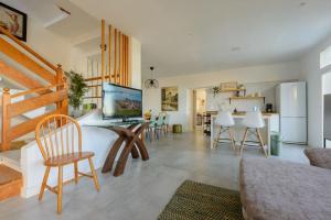 a living room with a table and chairs and a kitchen at Villa con piscina y vista al mar in Moya