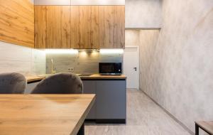 a kitchen with a counter with chairs and a microwave at Nyvky Like Home - Manchattan City - Квартира 290-2 in Kyiv