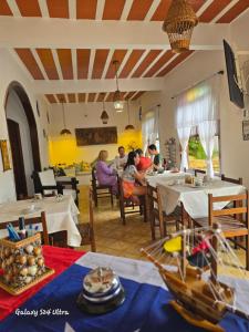 a group of people sitting at tables in a restaurant at Pousada Casa de Buzios in Búzios