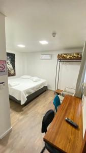 a room with a bed and a desk and a table at Hotel Zagonel in Chapecó +22 photos
