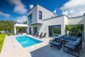 a villa with a swimming pool and a house at Villa Vivre in Ližnjan