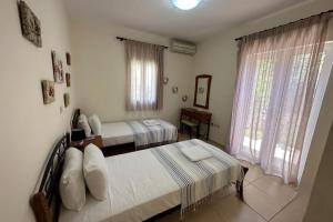 a bedroom with two beds and a mirror at Villa Ionion Pelagos - infinity pool with magnificent sea views! in Vlachata