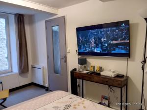 pokój hotelowy z telewizorem na ścianie w obiekcie ENTRE VILLE ET CANAL, calme ET central !Gare à 700 m w mieście Narbona