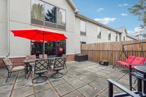 a patio with a table and a red umbrella at Quality Inn & Suites Dawsonville in Dawsonville
