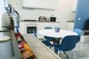 a kitchen with a white table and blue chairs at Snuggly Blue Home in Florence