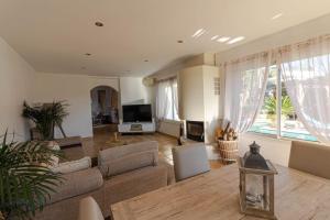 a living room with a couch and a tv at Charmante Maison de village- les adrets in Les Adrets de l'Esterel
