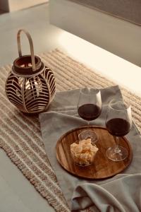 two glasses of wine and a bowl of food on a table at Palermo Inn Boutique Arte in Palermo