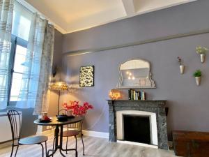 カルカソンヌにあるO'DE- Centre ville - proche cité médiévale -canal du midi - Wifi - Idéal couple et professionnelの暖炉とテーブルのあるリビングルーム
