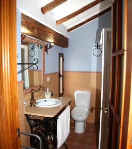 a bathroom with a toilet and a sink at Apartamentos Tío José María in Hinojares +50 photos