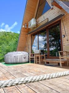 a porch of a log cabin with a wooden deck at Casuta dintre nuci in Blăjeni +13 photos