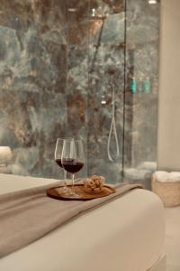 a glass of wine sitting on a bed with a towel at Palermo Inn Boutique Arte in Palermo