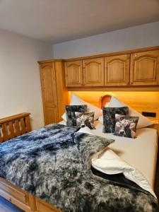 a bedroom with a large bed with wooden cabinets at ALPENCHALET LENGAU im Bergsteigerdorf Ginzling Dornauberg in Dornauberg