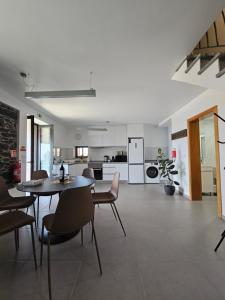 a kitchen and dining room with a table and chairs at Quinta das Rosas 6 Amaizing Seaview Trekking Beach in Estreito da Calheta