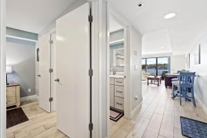 a white room with a kitchen and a dining room at 233 Edgewater Inn in Charlevoix +19 photos