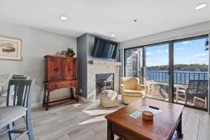 a living room with a fireplace and a view of the water at 233 Edgewater Inn in Charlevoix