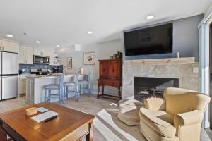 a living room with a fireplace with a tv above it at 233 Edgewater Inn in Charlevoix