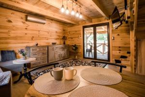 a living room with two tables in a log cabin at Leśny domek in Białowieża