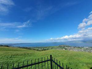 a fence in a field with a view of the water at Aorangi Peak Cabins 5 by Tiny Away in Rotorua +14 photos