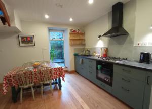 een keuken met een tafel en een fornuis bovenste oven bij No 14 -A Cosy Townhouse in Westport in Westport