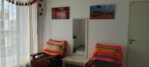 a living room with two chairs and a mirror at Departamento el estadio in Santiago del Estero