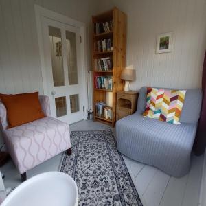 een woonkamer met een bank en een stoel bij No 14 -A Cosy Townhouse in Westport in Westport +7 foto's