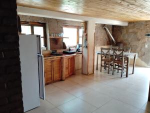 a kitchen with a refrigerator and a table with chairs at Balcón serrano 2 in El Volcán