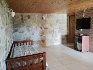 a bedroom with a bed and a stone wall at Balcón serrano 2 in El Volcán