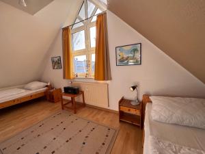 a attic bedroom with a bed and a window at Deichblick10 in Schillig
