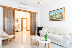 a living room with a white couch and tables at Godi Fiorenza Suite - Duomo a 15 Minuti e Aeroporto a 4 Minuti con Tramvia T2 in Florence