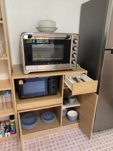 um micro-ondas sentado em cima de uma prateleira em The Garden House em Chiang Rai