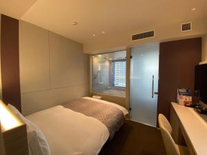Postel nebo postele na pokoji v ubytování APA Hotel Keikyukamata Ekimae