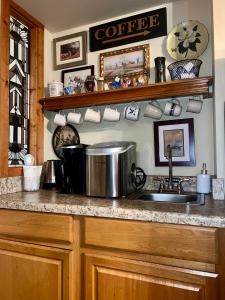 a kitchen with a sink and a counter with cups at Downtown Primrose Piedmont House in Eureka Springs