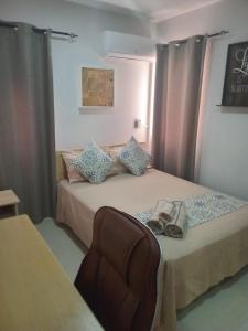 a bedroom with two beds with curtains and a purse at Noah Apartment Flic en Flac in Flic-en-Flac