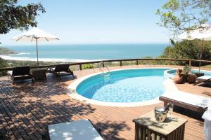 una piscina en una terraza con vistas al océano en Bangalore Suites, en Garopaba